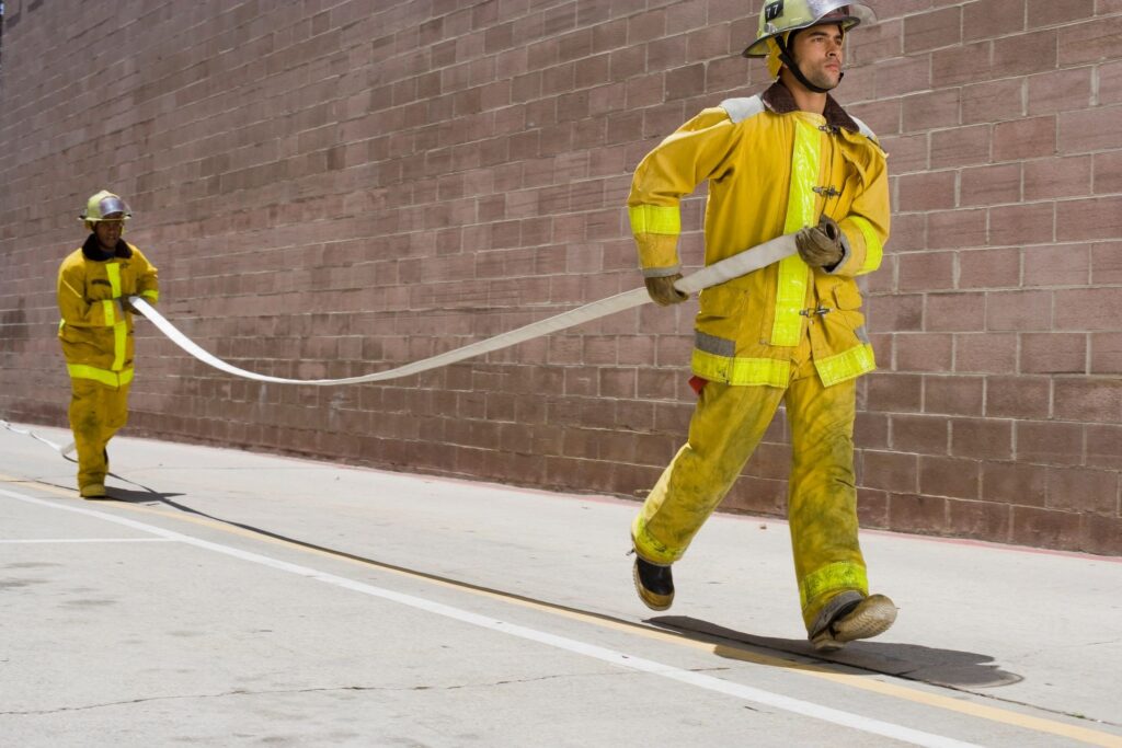 Firefighters carrying hose