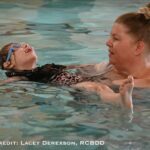 Sophia Watts works on her back float with her swim buddy Julie Hoylman.