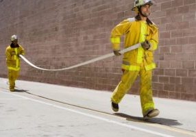 Firefighters carrying hose